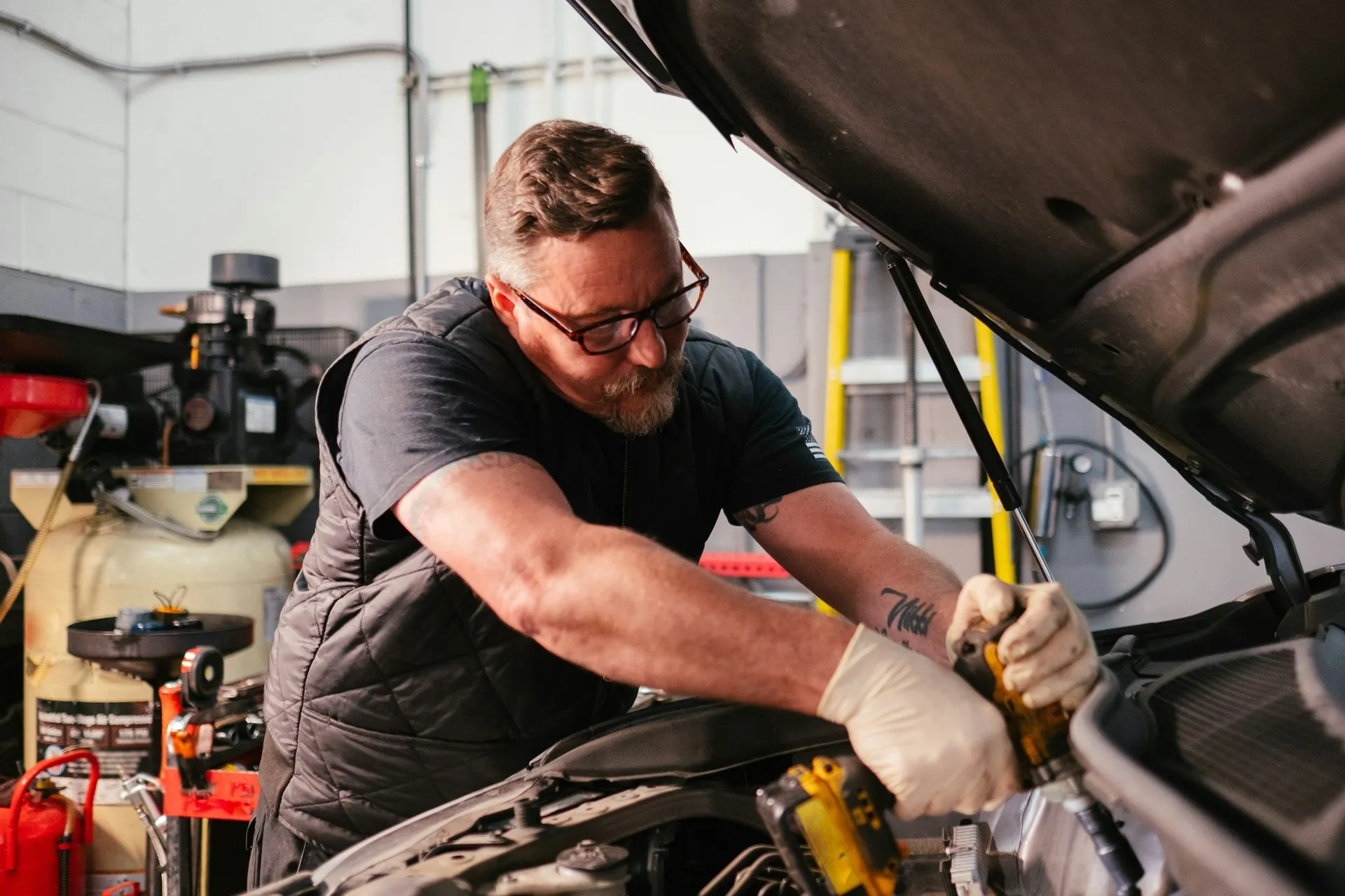 Mechanic doing auto repair under the hood of a car