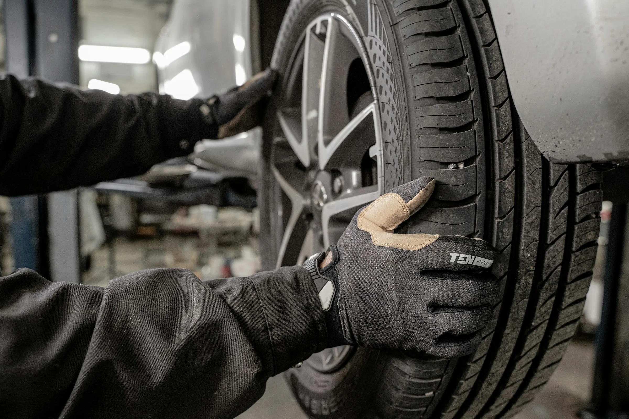 Mechanic working on a car tire in a garage